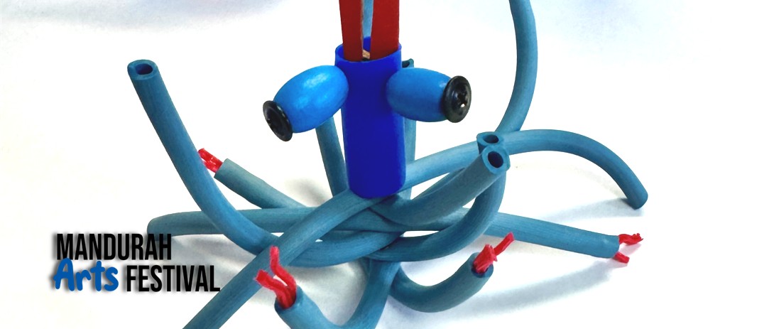 A handmade octopus-like creature made of blue tubing and reused plastic sits against a white background